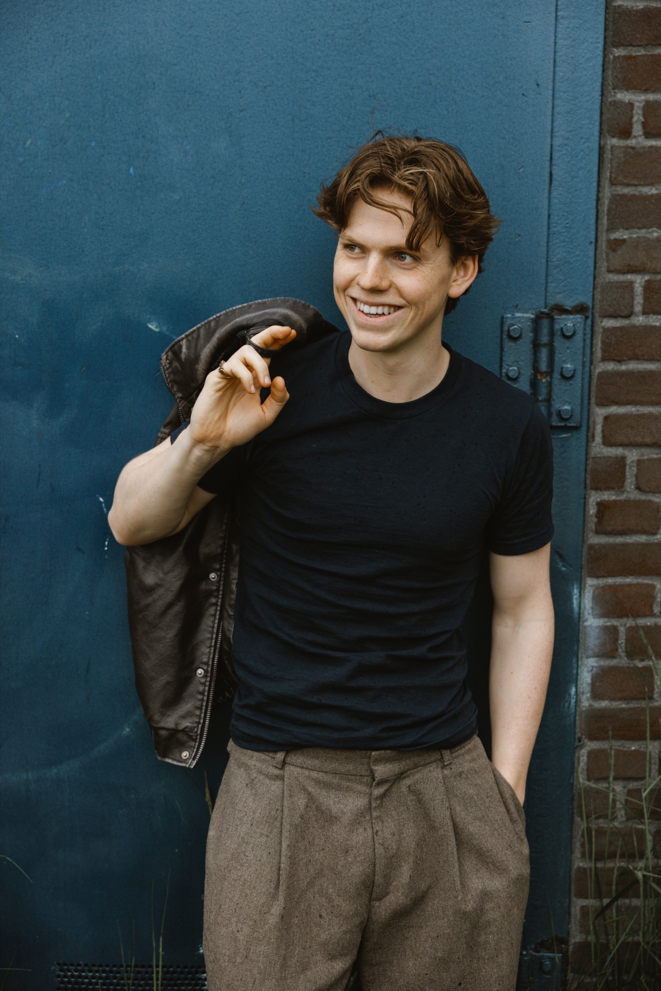 Senne breed lachend met zijn jas over de schouder